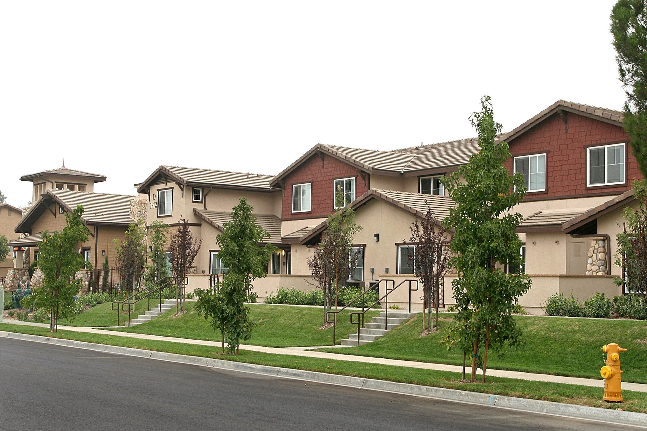 A row of houses with a yellow fire hydrant in front of them.